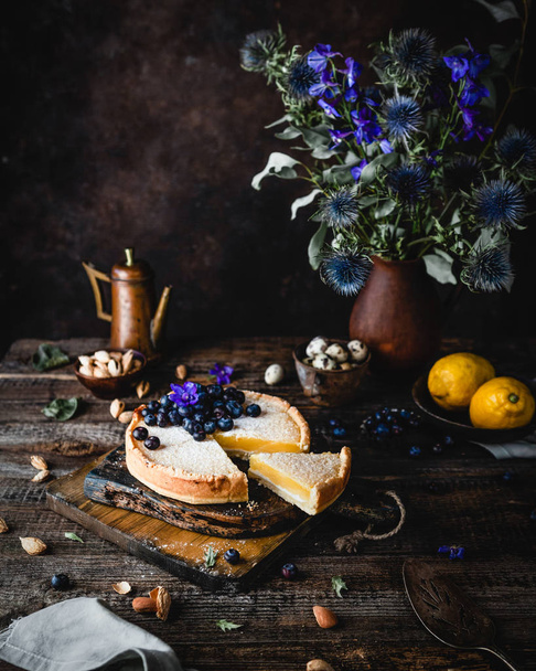 Homemade Lemon pie decorated with blueberries on wooden table - 写真・画像