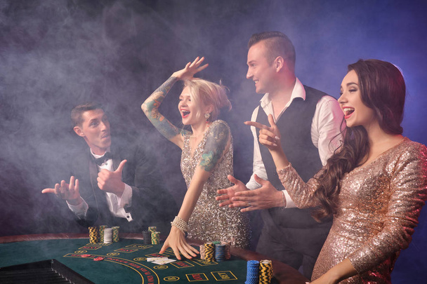 Group of a stylish rich friends are playing poker at casino. - Foto, immagini