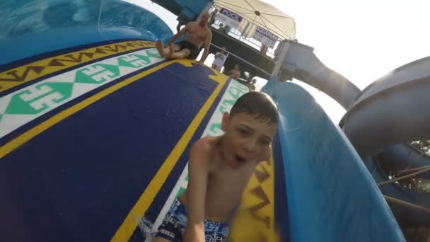 Alanya, Turkey - June 21, 2019:  Jolly view of an active small kid smiling and sliding down on a large and wide slope in Alanya resort in summer in slow motion. - Filmagem, Vídeo