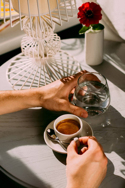 Фото завтрака в светлом современном кафе с эспрессо, современным модным десертом и стаканом воды
 - Фото, изображение