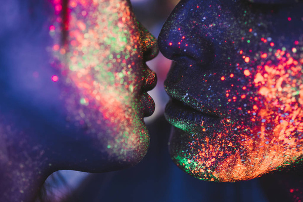 Paar zoenen in de Disco Club met fluorescerende schilderijen op t - Foto, afbeelding