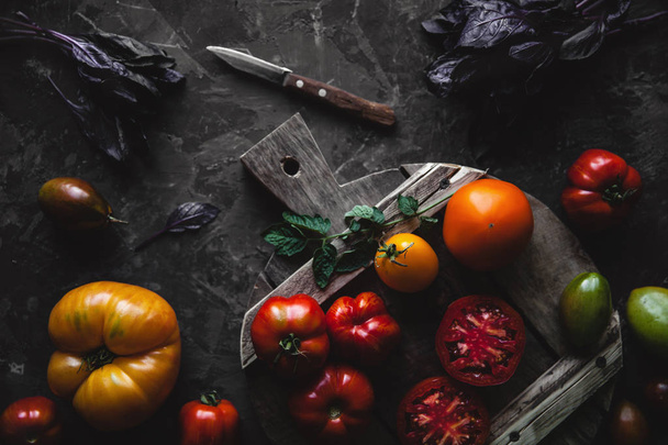 Composition with delicious tomatoes, wooden board and products on grey background, healthy food - Foto, immagini