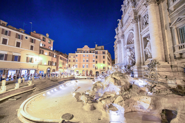 Rzym, Włochy-czerwiec 2014: turyści odwiedzają Fontannę di Trevi o zmierzchu.  - Zdjęcie, obraz