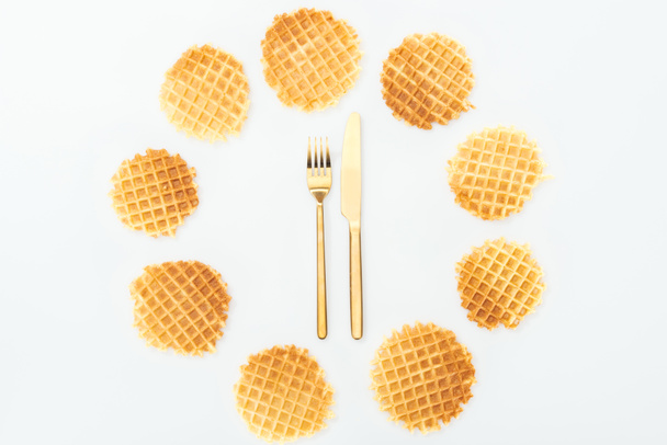 top view of waffles in circle with fork and knife in middle isolated on white - Foto, Imagem
