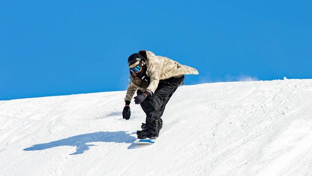 Сноубордист в действии на трассе со свежим снегом
 - Фото, изображение