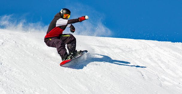 Snowboarder en acción en la pista con nieve fresca
 - Foto, imagen