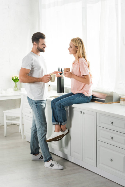 schönes Paar mit Tassen Kaffee beim Frühstück in der Küche - Foto, Bild