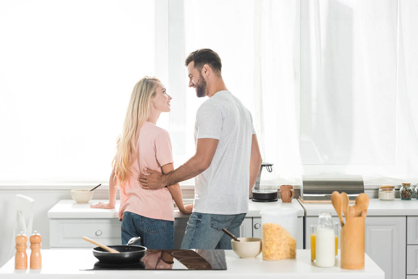 back view of beautiful couple during breakfast at kitchen - Valokuva, kuva