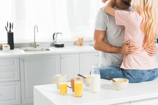 cropped view of couple hugging on Kitchen Counter during breakfast at kitchen - Φωτογραφία, εικόνα