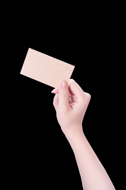 Young asia clean girl hand holding a blank kraft brown paper card template isolated on black background, clipping path, close up, mock up, cut out - Foto, imagen