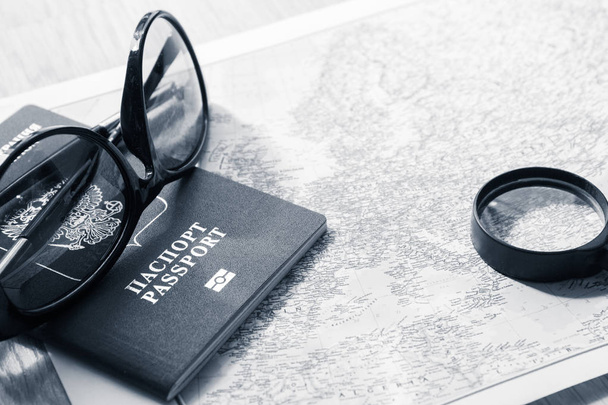 Abenteuer-Konzept. Sonnenbrille und Reisepass auf der Karte. Schwarz-Weiß-Foto - Foto, Bild
