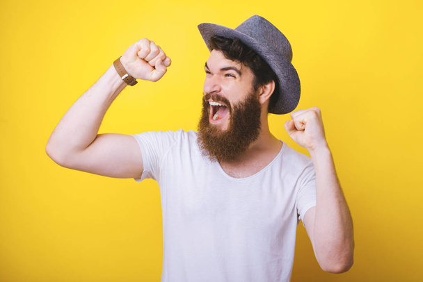 Молодий бородатий чоловік робить жест переможця, що кричить про щастя. концепція Перемоги
. - Фото, зображення