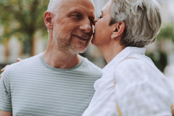 Smiling mature man and woman hugging outdoors - Fotó, kép