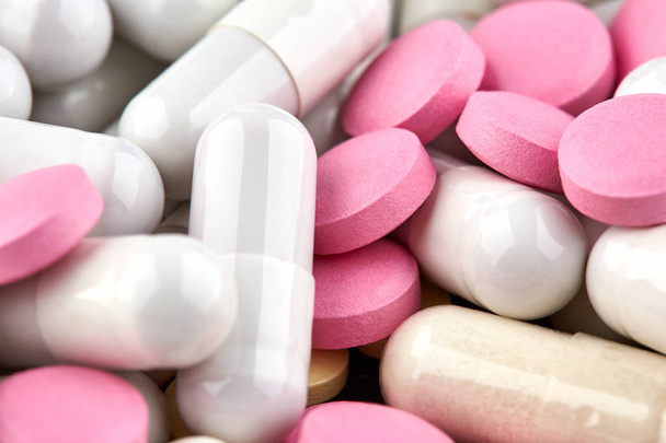 Close-up photo of white capsules and pink pills - Foto, imagen