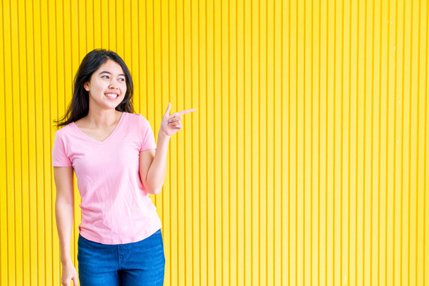 young asian woman happiness standing on yellow wall - Φωτογραφία, εικόνα