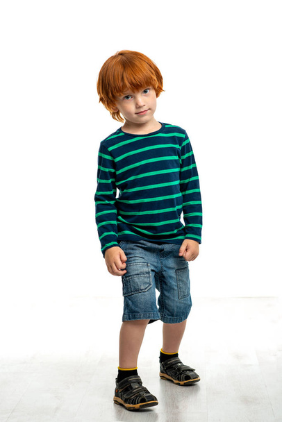 Beyaz karşı gülümseyen kızıl saçlı bir çocuğun tam uzunlukta portre  - Fotoğraf, Görsel