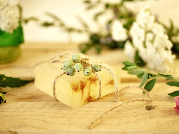 Natural soap,  plants and berries on a wooden table, spa procedures, body care, healthy lifestyle - Photo, Image