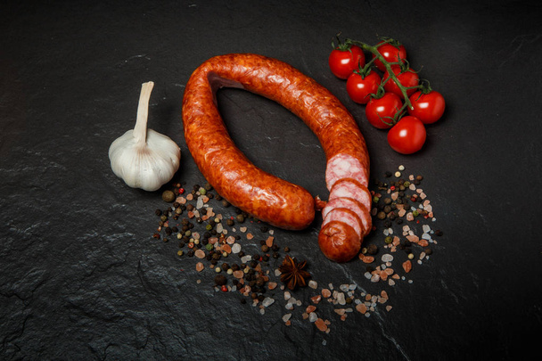 vista superior de salsicha seca defumada com alho e tomate cereja
 - Foto, Imagem