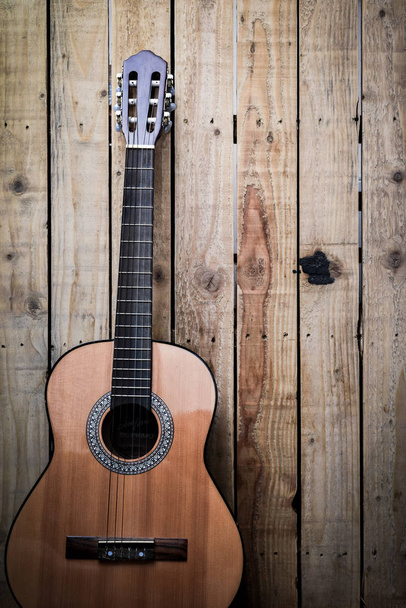 Акустическая гитара на деревянном фоне винтажного стиля. Копирование космического остроумия
 - Фото, изображение