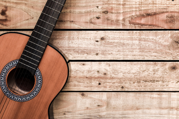 Акустическая гитара на деревянном фоне винтажного стиля. Копирование космического остроумия
 - Фото, изображение
