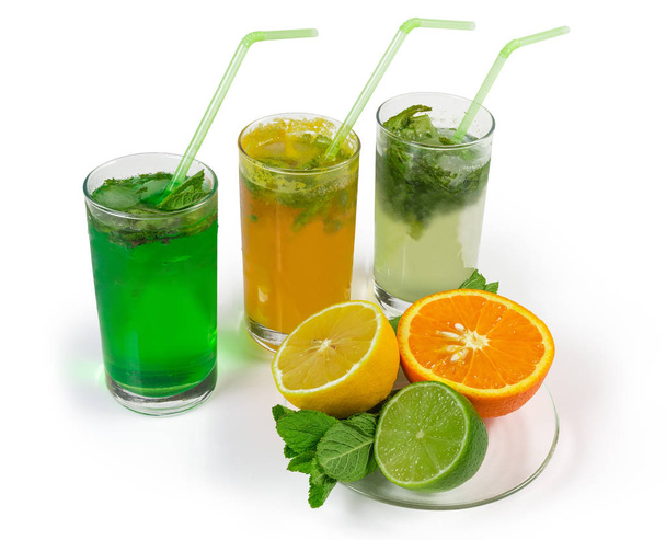 Bebidas frías de menta con diferentes cítricos sobre fondo blanco
 - Foto, imagen