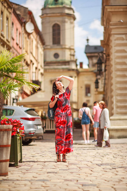 Pensive woman in long colorful dress on street of tourist old - Foto, imagen