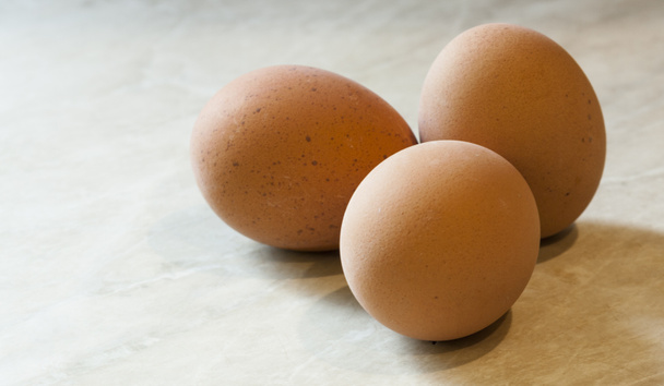 Курячі яйця на мармуровій поверхні
 - Фото, зображення