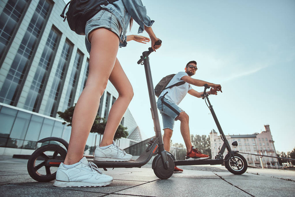 Deux amis profitent de la journée d'été avec leurs scooters électriques
 - Photo, image