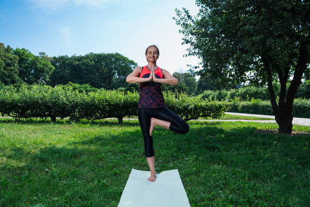 50 years old woman practice yoga outdoor. - Фото, зображення