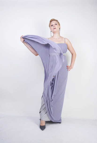 elegant thick female in a grey long dress. pretty plus size woman in evening dress standing on white studio background. short hair chubby girl in gray clothes posing alone. - Φωτογραφία, εικόνα