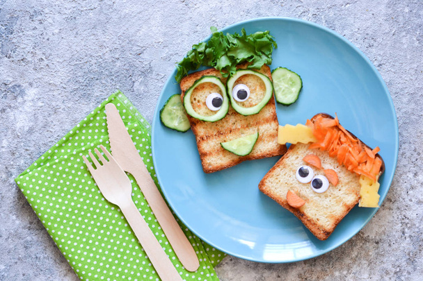 Funny faces - lunch for the child. Sandwich with vegetables.  - Foto, afbeelding
