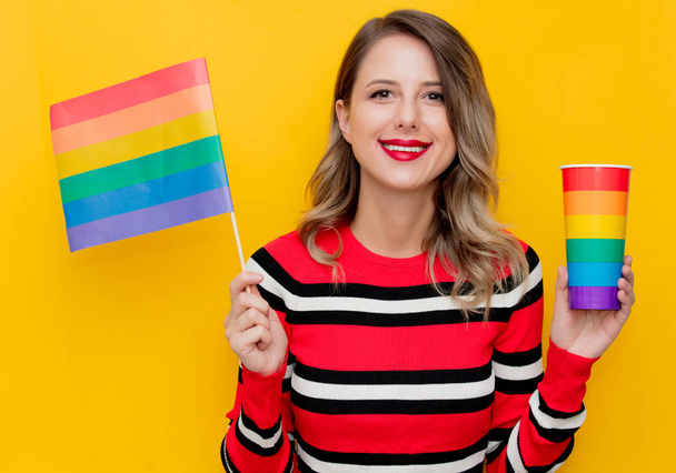 Young woman in red striped sweater with cup and LGBT flag - Photo, Image