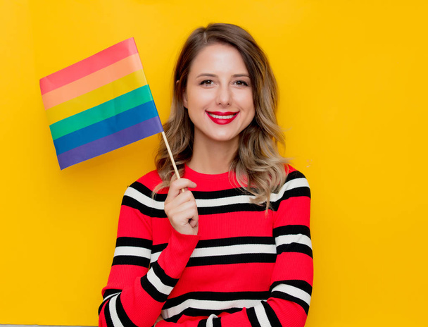 Young woman in red striped sweater with LGBT flag  - Photo, Image