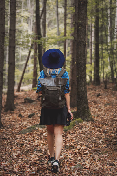 Młoda kobieta z lornetką i plecakiem w lesie  - Zdjęcie, obraz