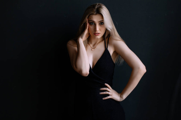 Beautiful slim young woman posing on a black background. Emotions - Valokuva, kuva