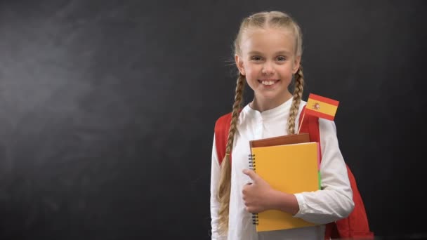 Vrolijke leerling Holding boeken met Tiny Spanje vlag, klaar om vreemde taal te leren - Video