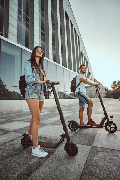 Jovem casal está desfrutando de scooters electro equitação
 - Foto, Imagem