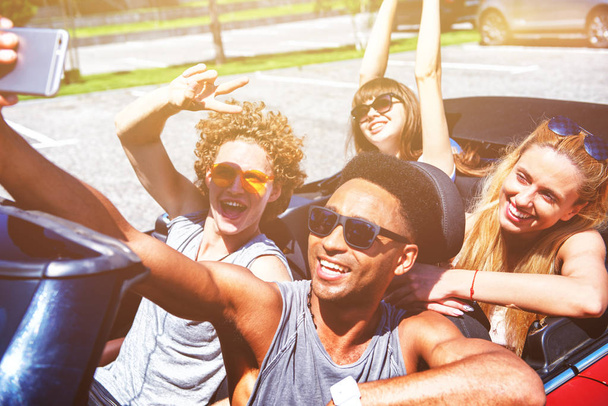 Jóvenes amigos se toman una selfie en un coche cabriolet
 - Foto, imagen