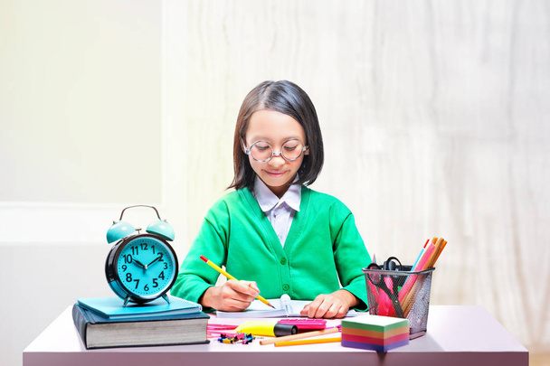 Asian cute girl in glasses learning with school stationary on th - Photo, Image