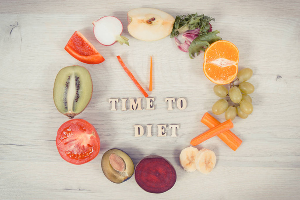 Fruit en groenten in de vorm van de klok tonen tijd aan dieet, gezond eten met vitaminen - Foto, afbeelding