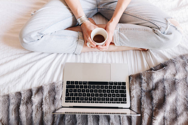 unrecognized woman drinking coffee and watching a Tv series on her laptop - Foto, imagen