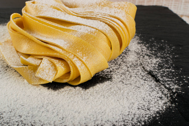 Pâtes italiennes jaunes crues Fettuccine, Fettuccelle ou Tagliatelle
 - Photo, image