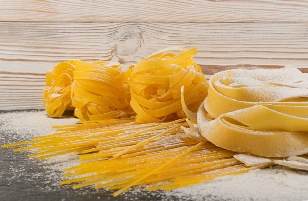 Raw yellow italian pasta pappardelle, fettuccine or tagliatelle - Photo, Image