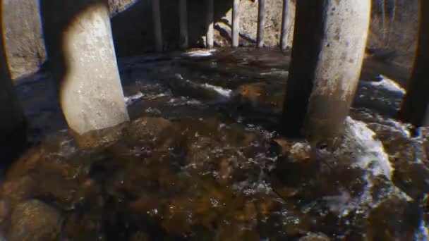 river flow under a reinforced concrete bridge in spring - Imágenes, Vídeo