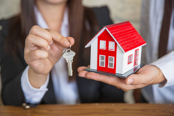 Агент по недвижимости с моделью дома и ключами, подпись клиента
 - Фото, изображение