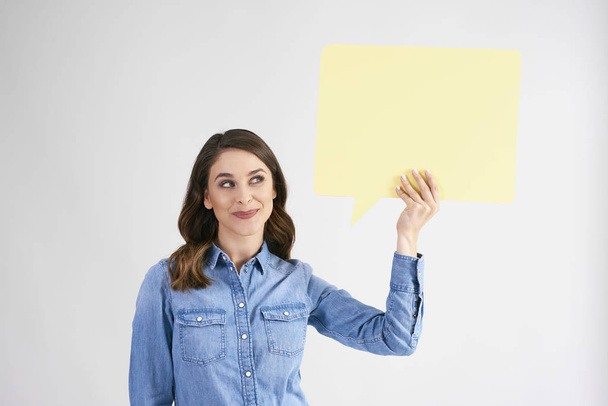 Young woman holding speech bubble with copy space  - Foto, afbeelding