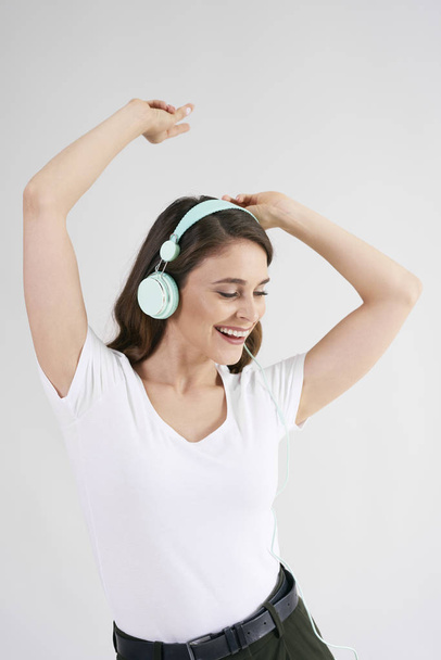 Hermosa mujer en auriculares escuchando música y bailando
  - Foto, Imagen