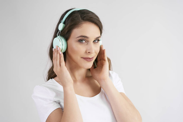 Portrait of young woman with headphones listening to music  - Fotografie, Obrázek