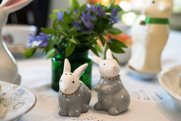 Aranyos díszkerámia dekoratív nyulak a húsvéti ebédlőasztal - Fotó, kép