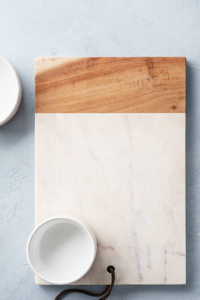 Rectangular marble and wooden serving board and a bowl. - Фото, изображение